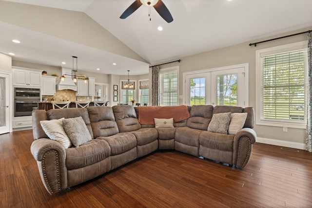 living room with ceiling fan with notable chandelier, dark hardwood / wood-style floors, and lofted ceiling