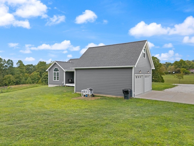 back of property featuring a lawn and a garage