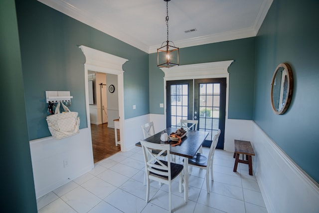 dining area with ornamental molding, light tile patterned floors, and french doors