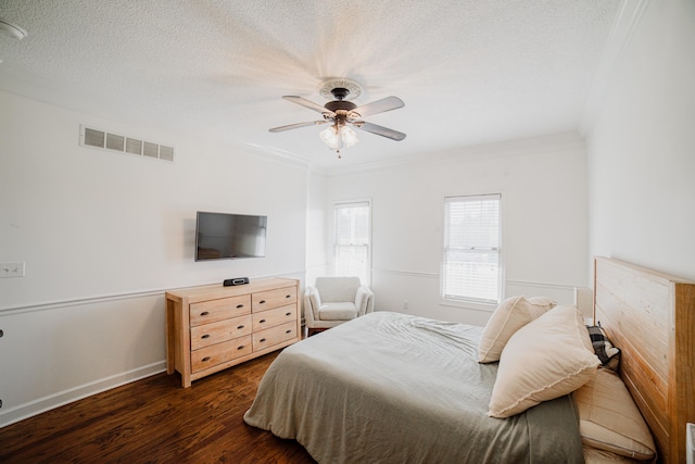 bedroom featuring ceiling fan, dark hardwood / wood-style flooring, crown molding, and a textured ceiling