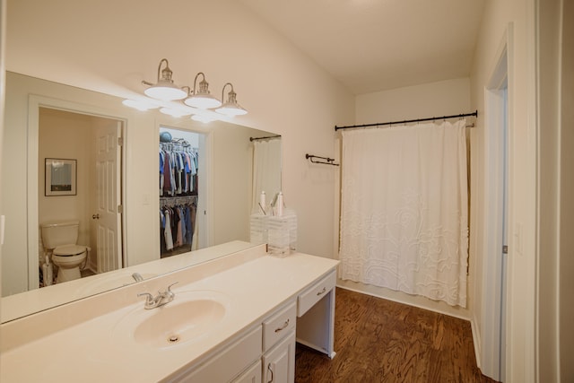 bathroom featuring curtained shower, toilet, vanity, and hardwood / wood-style flooring