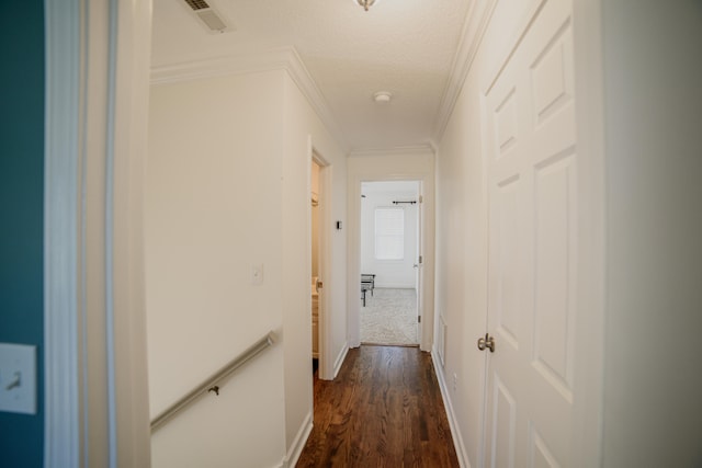 hallway with a textured ceiling, dark hardwood / wood-style floors, and ornamental molding