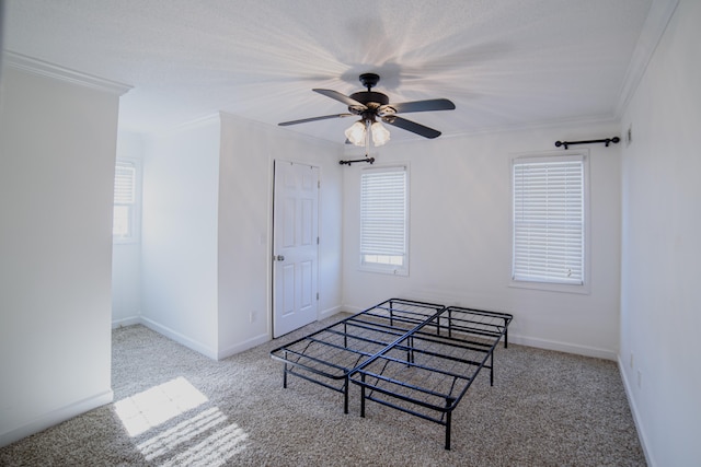 bedroom with light colored carpet, multiple windows, crown molding, and ceiling fan