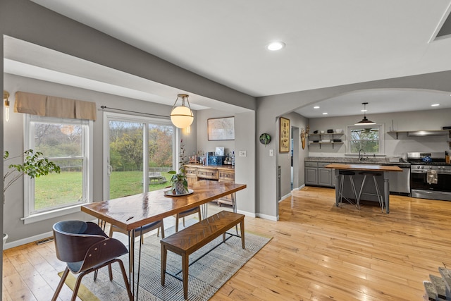 dining space with sink, a wealth of natural light, and light hardwood / wood-style floors