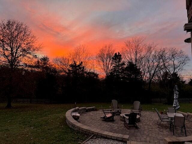 yard at dusk with an outdoor fire pit and a patio area