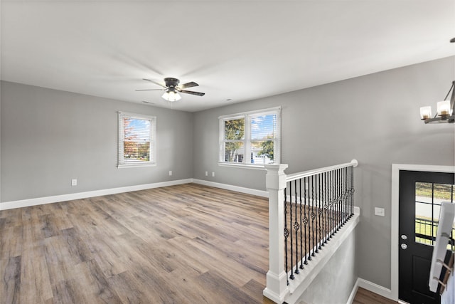 foyer featuring a healthy amount of sunlight, ceiling fan with notable chandelier, and light hardwood / wood-style floors