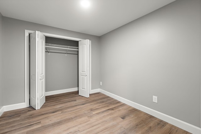 unfurnished bedroom featuring hardwood / wood-style floors and a closet