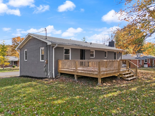 rear view of property featuring a yard and a wooden deck