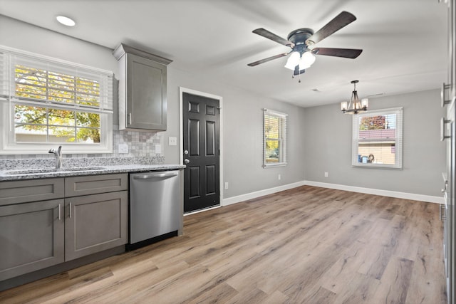 kitchen featuring stainless steel dishwasher, decorative backsplash, gray cabinets, and light wood-type flooring