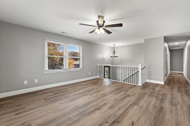 unfurnished room featuring hardwood / wood-style floors and ceiling fan with notable chandelier