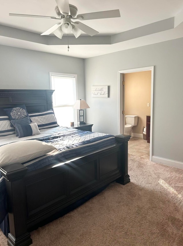 carpeted bedroom with ensuite bath and ceiling fan