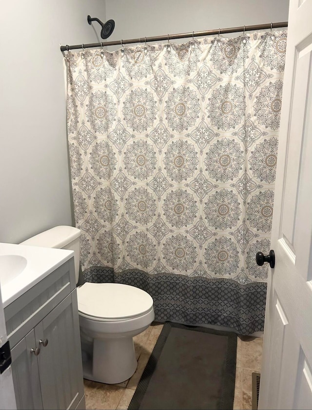 bathroom featuring tile patterned flooring, vanity, and toilet