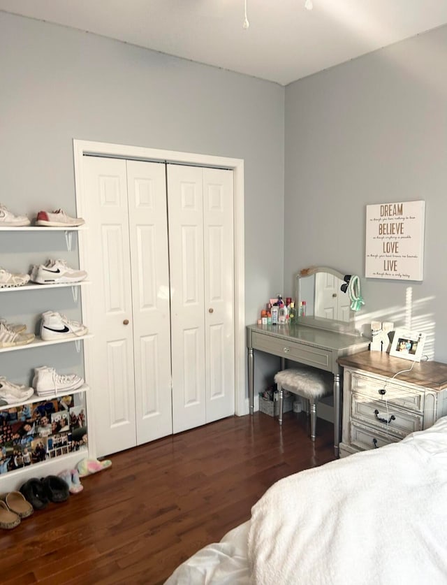 bedroom with dark hardwood / wood-style flooring and a closet