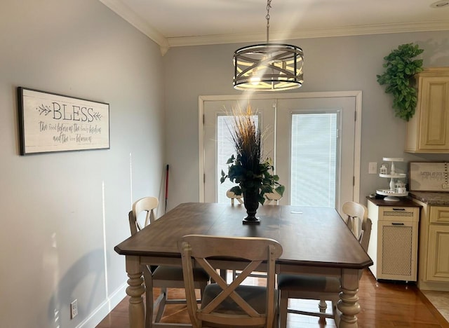 dining space featuring ornamental molding, an inviting chandelier, and dark wood-type flooring