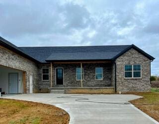 view of front of house with stone siding and a front lawn