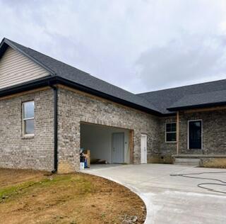 view of side of property with a garage and concrete driveway