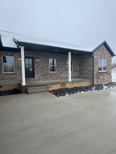 view of front of property with a patio area and brick siding