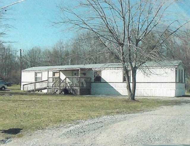 view of front facade with a wooden deck and a front lawn