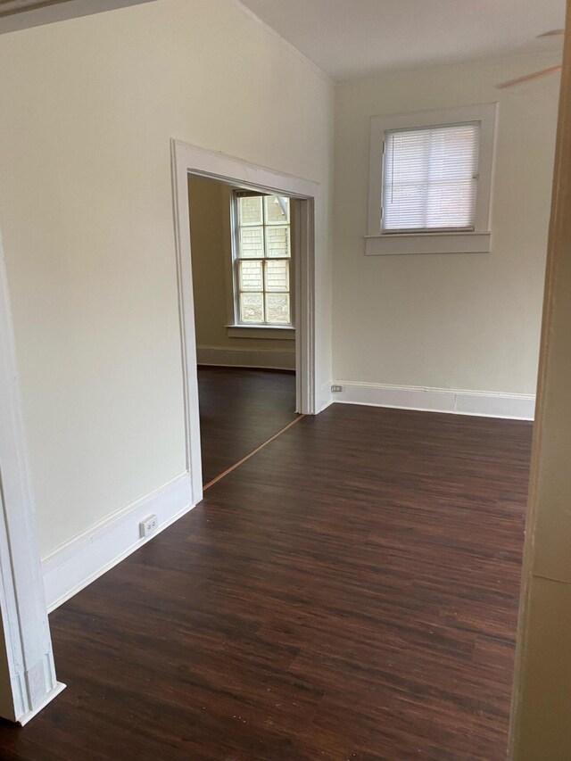 unfurnished living room with built in shelves, dark hardwood / wood-style flooring, and a brick fireplace