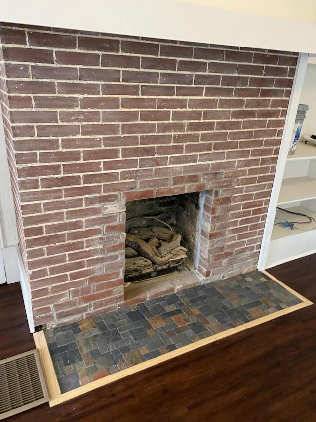 details with wood-type flooring and a brick fireplace