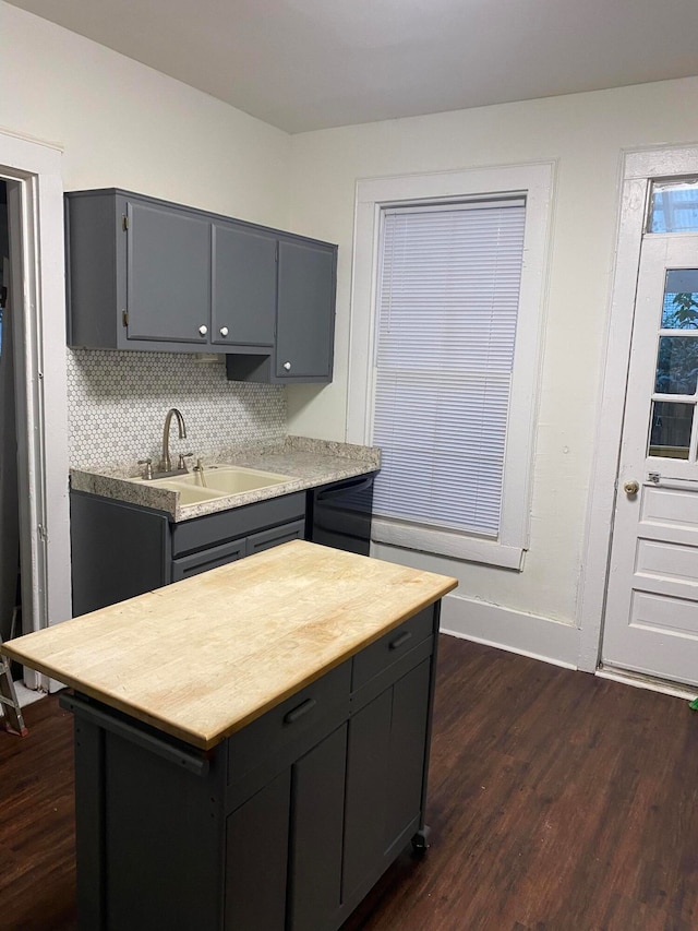 kitchen featuring dark hardwood / wood-style flooring, tasteful backsplash, sink, a center island, and gray cabinets