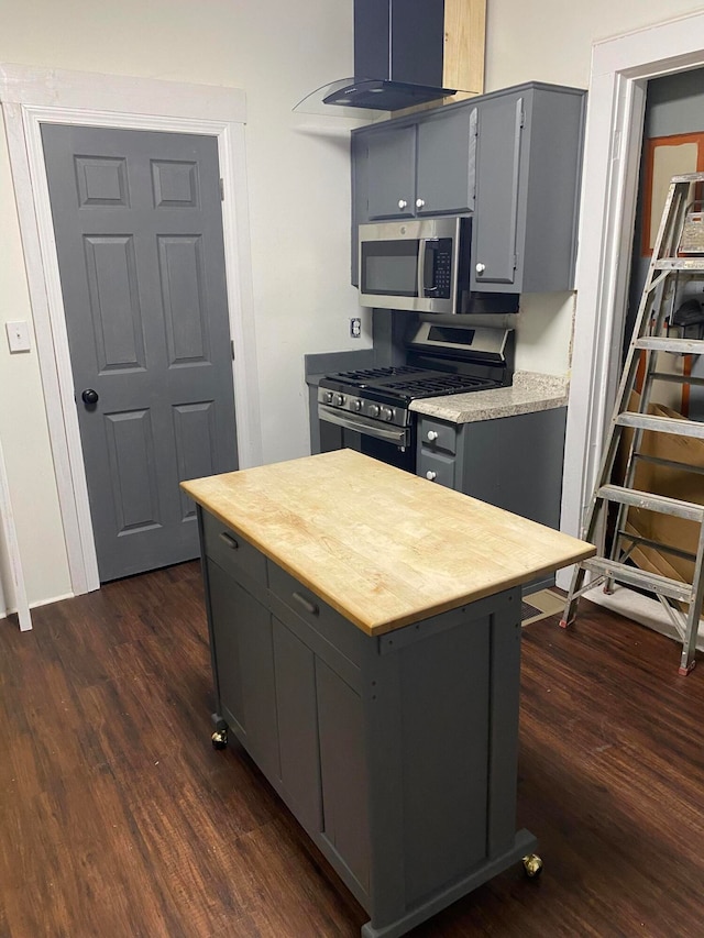 kitchen featuring gray cabinetry, a center island, dark wood-type flooring, and appliances with stainless steel finishes