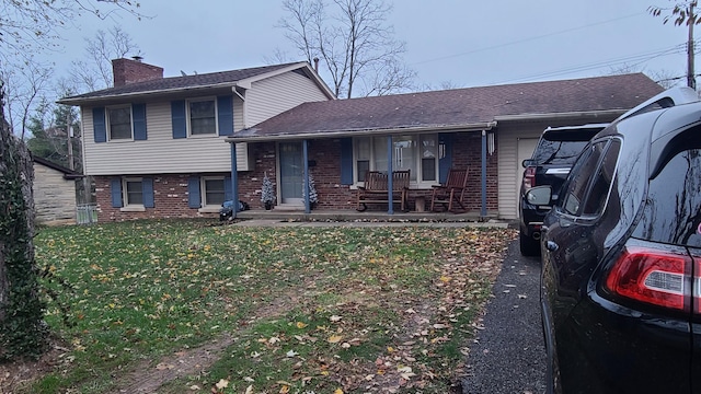 split level home with covered porch and a front lawn