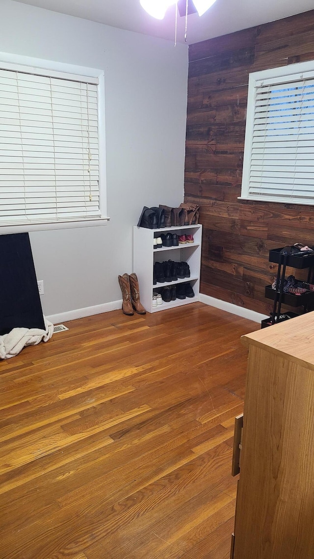 interior space featuring dark hardwood / wood-style flooring and wooden walls