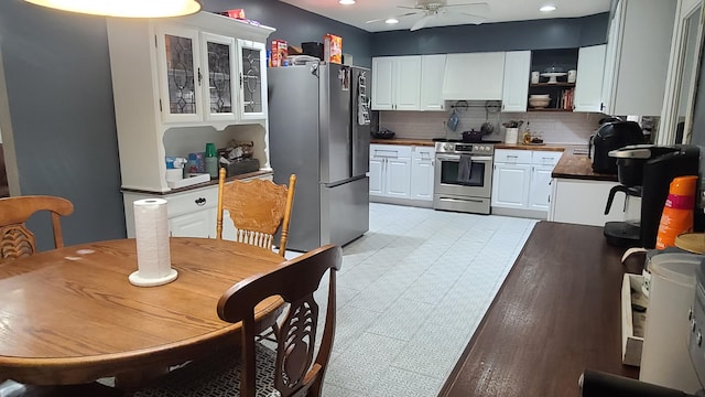 kitchen with appliances with stainless steel finishes, light wood-type flooring, tasteful backsplash, ceiling fan, and white cabinets