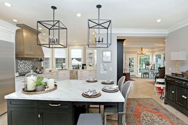 kitchen with a center island, backsplash, white cabinets, and decorative light fixtures