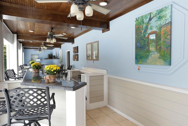 kitchen featuring light tile patterned floors, wood ceiling, and beamed ceiling