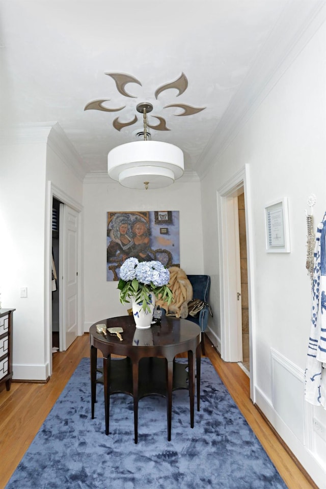 dining room featuring hardwood / wood-style floors and ornamental molding