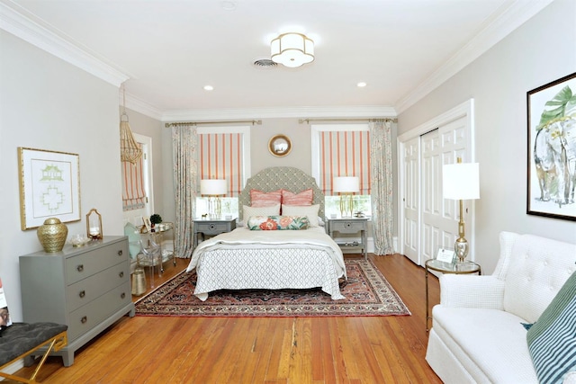 bedroom with ornamental molding, light hardwood / wood-style flooring, and multiple windows