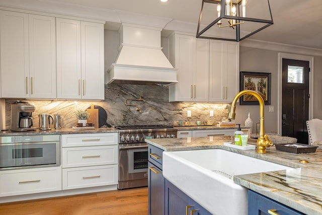 1602 Winners Cir # 41, Lexington, KY 40513 - kitchen with stainless steel appliances, custom range hood, crown molding, blue cabinets, and white cabinetry