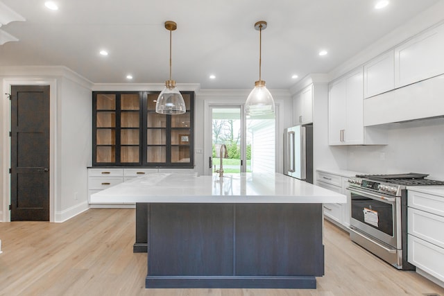 kitchen featuring decorative light fixtures, appliances with stainless steel finishes, light stone counters, and white cabinetry