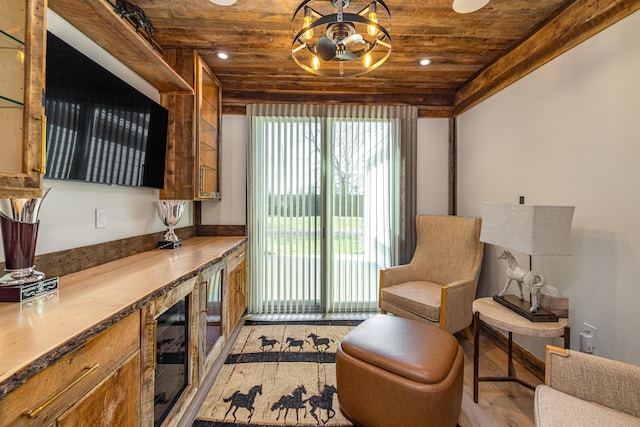 sitting room featuring wine cooler, light hardwood / wood-style flooring, and wooden ceiling