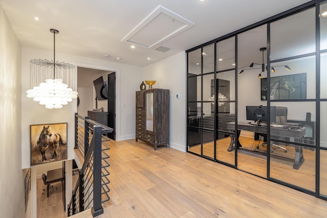 hall featuring an inviting chandelier and light hardwood / wood-style floors