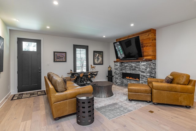 living room featuring light wood-type flooring and a fireplace