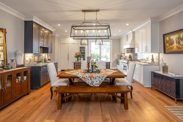 dining area featuring light wood-type flooring and ornamental molding