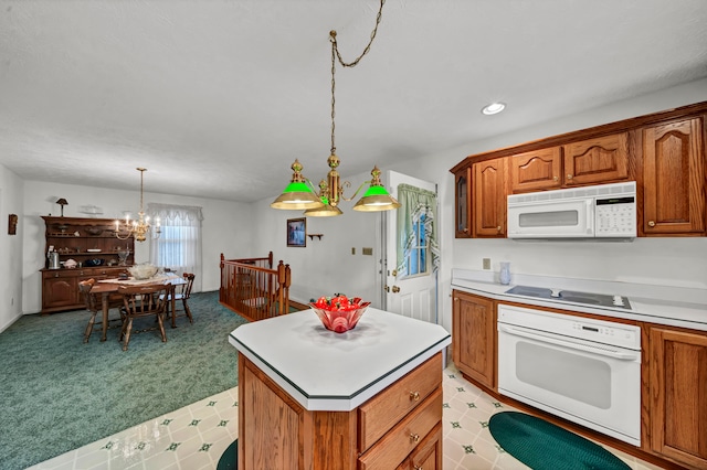 kitchen featuring white appliances, light colored carpet, pendant lighting, a chandelier, and a kitchen island