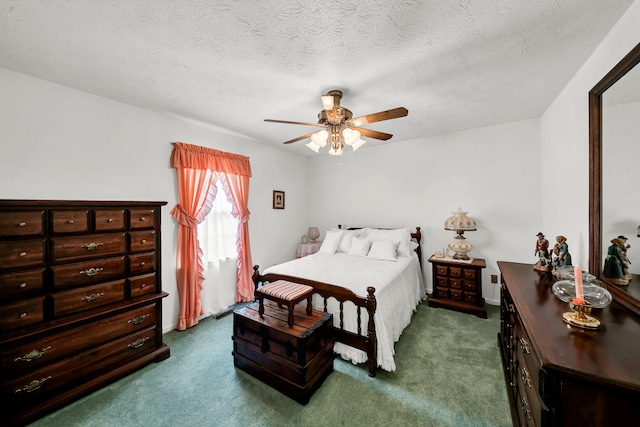 bedroom featuring ceiling fan, dark carpet, and a textured ceiling