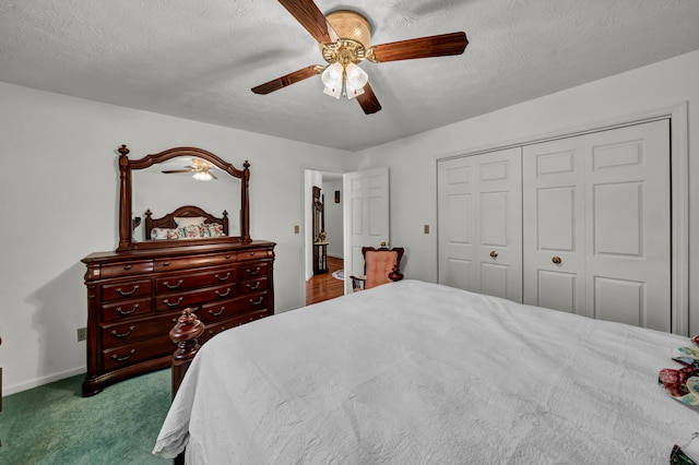 bedroom featuring ceiling fan, light colored carpet, a textured ceiling, and a closet