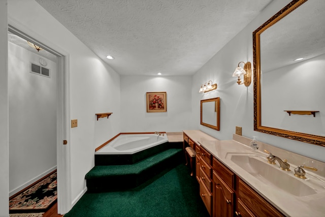 bathroom featuring vanity, a bath, and a textured ceiling