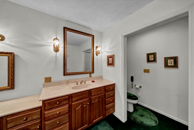 bathroom featuring vanity, a textured ceiling, and toilet