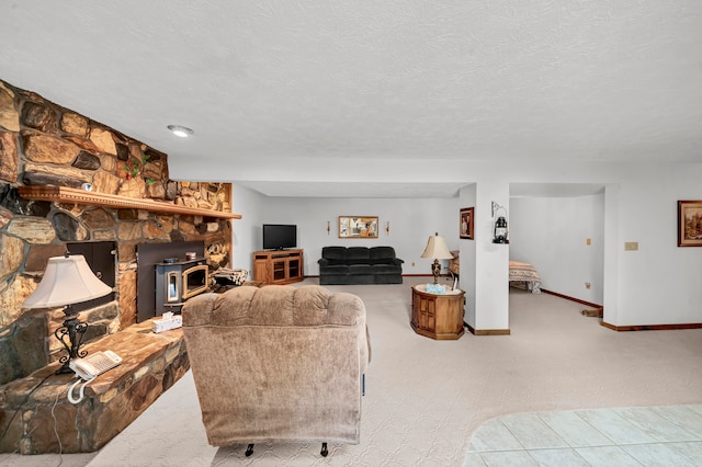 living room featuring light colored carpet, a wood stove, and a textured ceiling