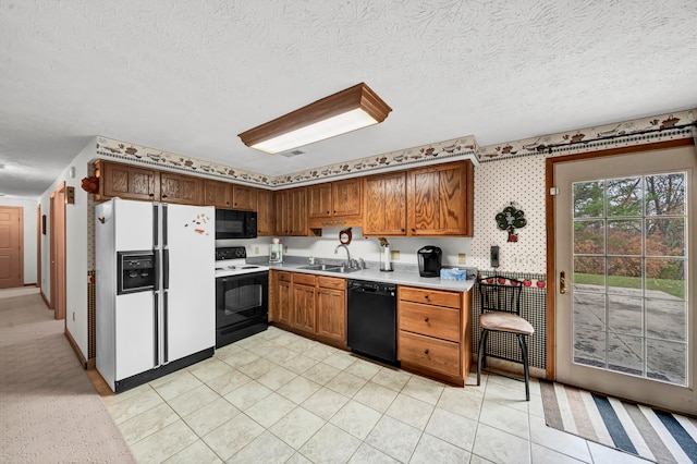 kitchen with a textured ceiling, sink, and black appliances