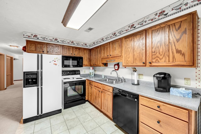 kitchen featuring sink, light colored carpet, and black appliances