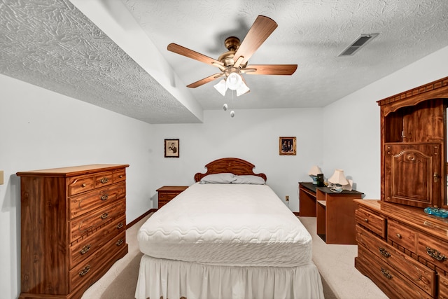 bedroom featuring ceiling fan, carpet floors, and a textured ceiling