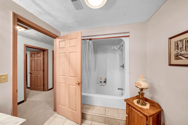 bathroom featuring tile patterned flooring, shower / bath combo with shower curtain, and a textured ceiling