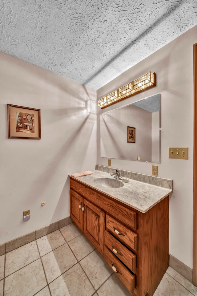 bathroom with a textured ceiling, vanity, and tile patterned floors